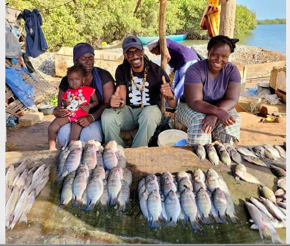Aliou Cissé, entraineur de l'équipe nationale de football avec les femmes vendeuses de poissons